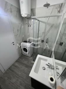 a bathroom with a sink and a washing machine at Interstellar 830 in Durrës