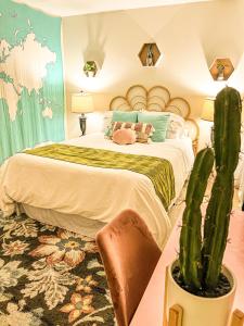 Un dormitorio con una cama grande y un cactus en Stylish 2 bedroom near Ontario Airport en Fontana