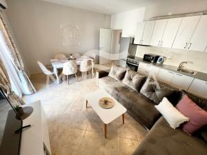 a living room with a couch and a table at Sunshine 781 in Durrës