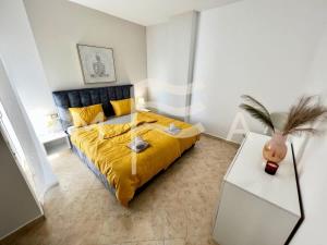 1 dormitorio con 1 cama con colcha amarilla en Sunshine 781, en Durrës