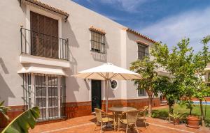 a table with an umbrella in front of a house at Gorgeous Home In Chipiona With Wifi in Chipiona