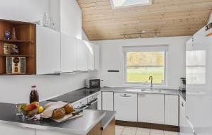 eine Küche mit weißen Schränken und einer Obstschale auf der Theke in der Unterkunft Beautiful Home In Idestrup With Kitchen in Bøtø By
