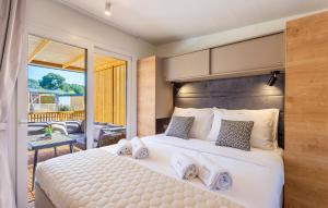 a bedroom with a large bed and a balcony at 2 Bedroom Amazing Home In Banjole in Banjole