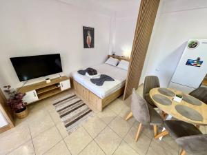 um quarto com uma cama, uma mesa e uma televisão em Vacation 939 em Durrës