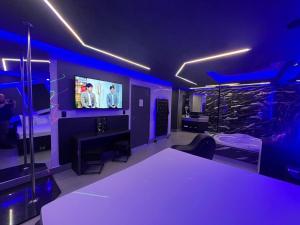 Prestige Motel 4 في سوروكابا: غرفة بها أضواء أرجوانية وغرفة بها تلفزيون