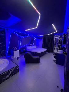 Prestige Motel 4 في سوروكابا: غرفة معيشة مع أضواء زرقاء على السقف