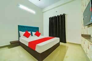 a bedroom with a large bed with red pillows at OYO H.S HOTEL in Bhopal