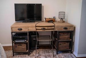 a wooden desk with a television on top of it at Family friendly getaway in North Richland Hills