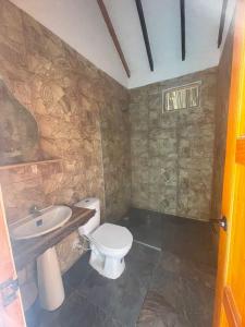 La salle de bains est pourvue de toilettes et d'un lavabo. dans l'établissement hotel palmares beach, à Palomino