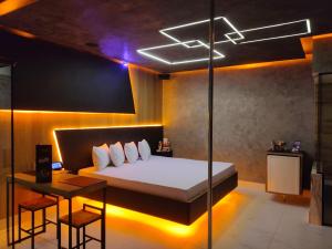 a bedroom with a bed and a table with a desk at Prestige Motel 5 in Sorocaba