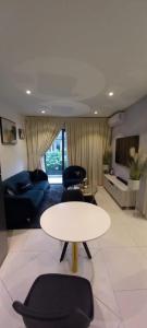 uma sala de estar com uma mesa branca e cadeiras em The Lennox Suite Room em Acra
