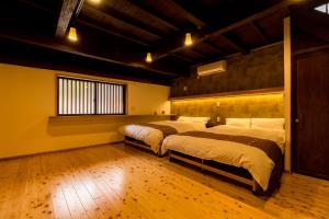 a room with four beds in it with a wooden floor at 城下町家 茶庭 飛び石 BBQ 筍 金蔵Kinzo in Ōtaki
