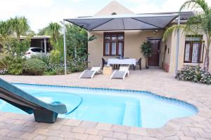 a house with a swimming pool with a table and a slide at Alakhe Self-Catering Accomodation Twin Bedroom in Oudtshoorn