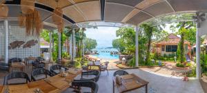 a restaurant with tables and chairs and a pool at Aochalong Villa Resort & Spa - SHA Plus in Chalong 