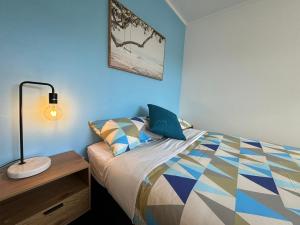 una camera da letto con un letto con una lampada sopra di Palm Tree Lodge a Paihia