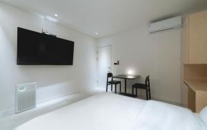 1 dormitorio con 1 cama y 1 mesa con sillas en The Hyoosik Aank Hotel Wolgot en Siheung