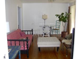 ein Wohnzimmer mit einem Sofa und einem Tisch mit Stühlen in der Unterkunft Mid-Century Modern meets Cajun Creole in Baton Rouge