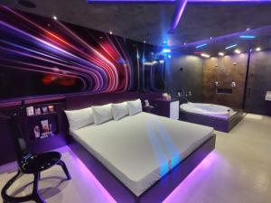 Prestige Motel 6 في سوروكابا: غرفة نوم مع سرير وحوض استحمام مع أضواء