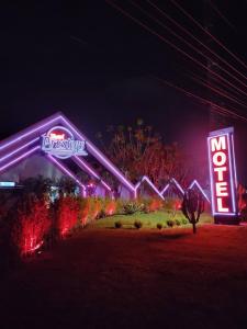 Prestige Motel 6 في سوروكابا: إطلالة ليلية على منتجع ديزني مع لافتات نيون