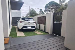 ein weißes Auto, das vor einem Haus parkt in der Unterkunft Bon Voyage in Werribee