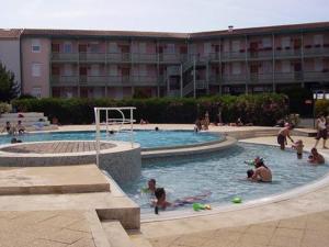a group of people playing in a swimming pool at Appartement 4 Pers. Terrasse Clim, Piscine Collective - FR-1-535-37 in Châtelaillon-Plage