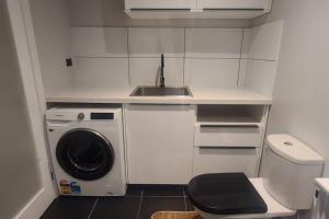 una pequeña cocina con fregadero y lavadora en Bon Voyage, en Werribee