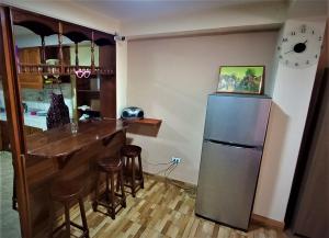 a kitchen with a bar and a refrigerator at Carlos Guest House 1 Cusco in Cusco