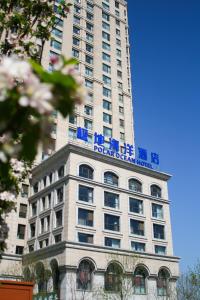 un edificio alto con un cartel encima en Tianjin Polar Ocean Hotel, en Binhai