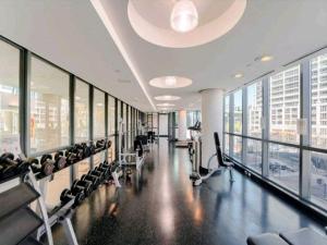a gym with chairs and treadmills in a building at CN Tower View w/ Free Parking, Pool & Gym and More in Toronto