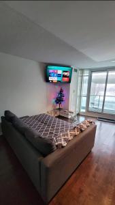 a bedroom with a large bed with a tv on the wall at CN Tower View w/ Free Parking, Pool & Gym and More in Toronto