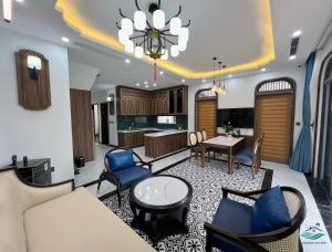 een woonkamer met een bank, stoelen en een tafel bij Rosa Villa - Sonasea - Vân Đồn 