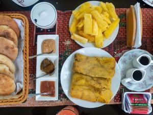 una mesa con platos de comida y patatas fritas en Cabañas Alpinas en Oxapampa, en Oxapampa