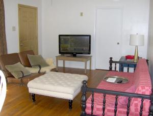 ein Wohnzimmer mit einem Bett und einem TV in der Unterkunft Mid-Century Modern meets Cajun Creole in Baton Rouge