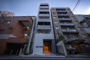 Un edificio de apartamentos con un pasillo en frente. en Dash Living Ueno Park, en Tokio