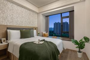 a bedroom with a large bed and a window at Somerset Star River Minhang Shanghai in Shanghai