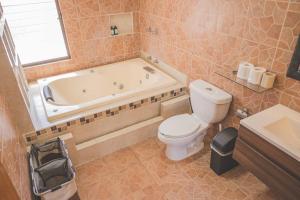 a bathroom with a tub and a toilet and a sink at Casa Vacacional, Lomas Cocoyoc in Texcalpan +22 photos