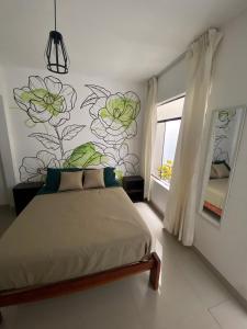 a bedroom with a bed with a flower mural on the wall at Hostel Killamoon Centro in Paracas
