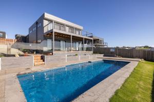 une maison avec une piscine en face d'une maison dans l'établissement Luxury Holiday Home, San Remo - Phillip Island, à San Remo