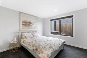 - une chambre blanche avec un lit et une fenêtre dans l'établissement Luxury Holiday Home, San Remo - Phillip Island, à San Remo