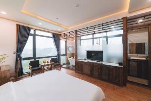 um quarto com uma cama grande e uma televisão em Greenview Hotel DaLat em Da Lat