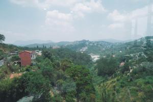 uitzicht op een stad vanaf een heuvel met bomen bij Greenview Hotel DaLat in Da Lat