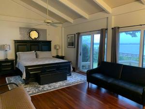 a bedroom with a bed and a couch and a window at Waterfront! Private Dock! Cottage in the City! in Beaufort