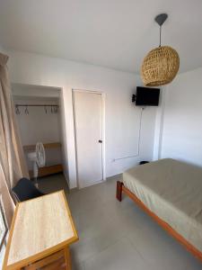 a bedroom with a bed and a table and a door at Hostel Killamoon Centro in Paracas