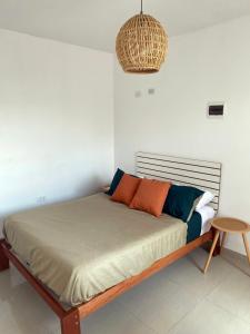 uma cama num quarto branco com em Hostel Killamoon Centro em Paracas