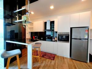 a kitchen with white cabinets and a black refrigerator at Landmark2 Spacious Studio w Wi-Fi Netflix in Kajang