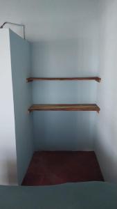a room with two wooden shelves on the wall at Punta Chilama in La Libertad
