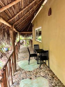 a patio with two chairs and a table in a building at Junto al Rio Bungalows & Suites in Sayulita