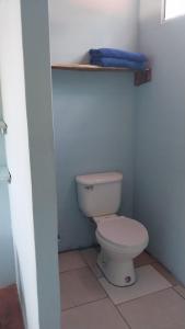 een badkamer met een toilet en een handdoek op een plank bij Punta Chilama in La Libertad