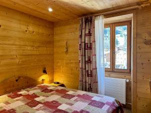 1 dormitorio con paredes de madera y 1 cama con ventana en Appartement La Clusaz, 3 pièces, 6 personnes - FR-1-437-111 en La Clusaz