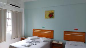 1 dormitorio con 2 camas y una foto en la pared en PLAZA HOTEL MARABÁ, en Marabá
